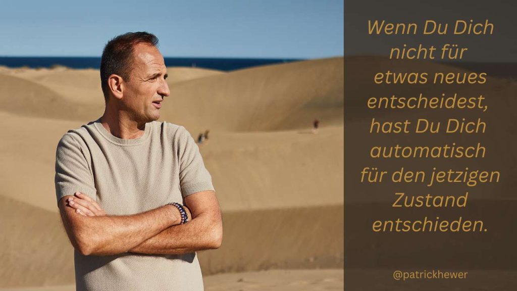 Patrick Hewer mit verschränkten Armen vor einer Düne – Symbol für Entschlossenheit und innere Stärke